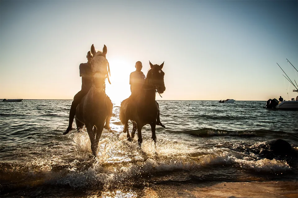 Sunset horse riding through the shallows at Anantara Bazaruto Island Resort