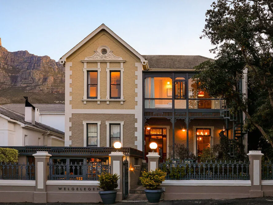 Welgelegen House Victorian exterior at dusk, with Table Mountain beyond.